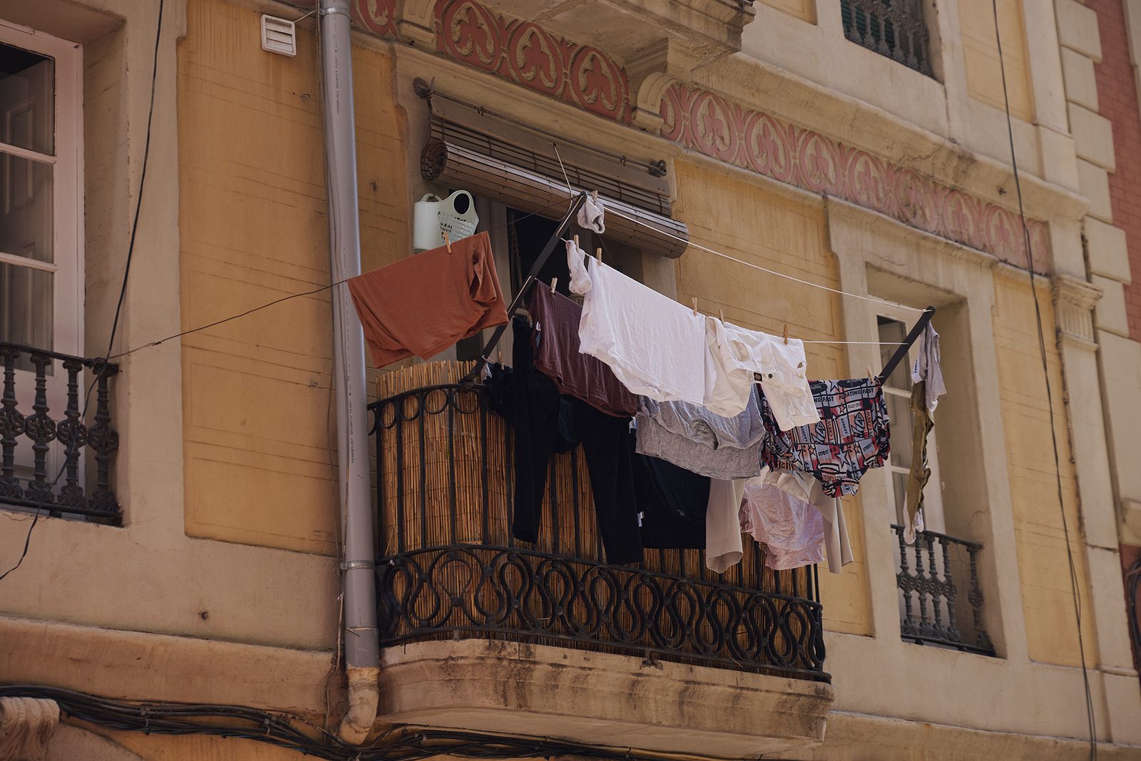 White sheets drying between weathered facades