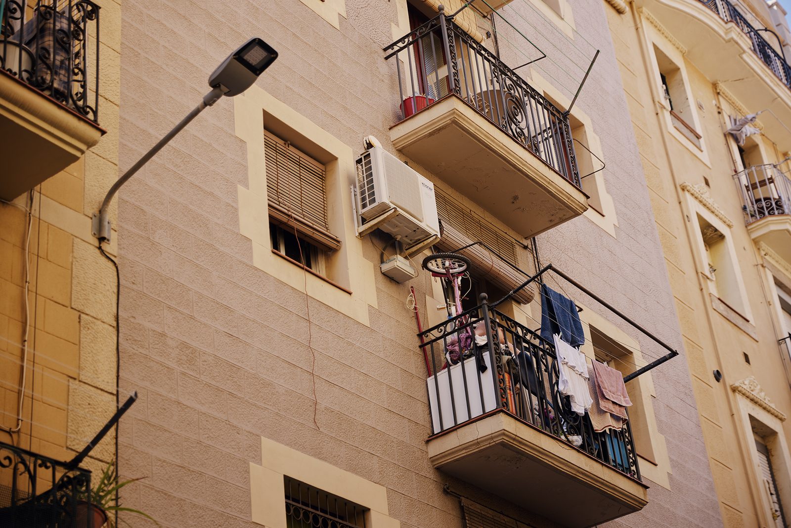 A street lamp against a sunlit apartment block