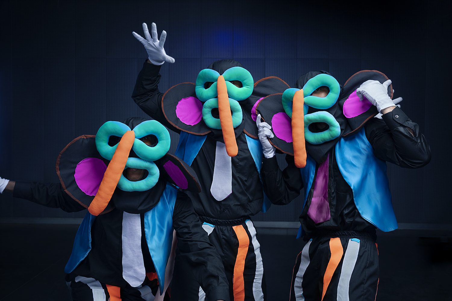 Costumed performers in neon light and dark suits