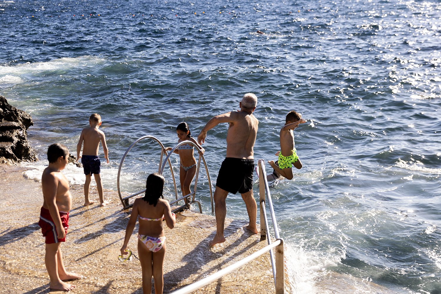 Bathers on the rocks beside the Mediterranean
