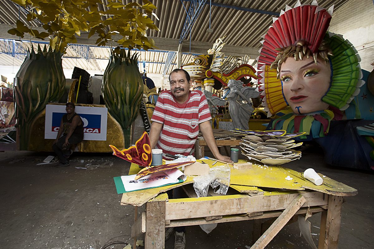 Artisans build giant float heads in a carnival workshop