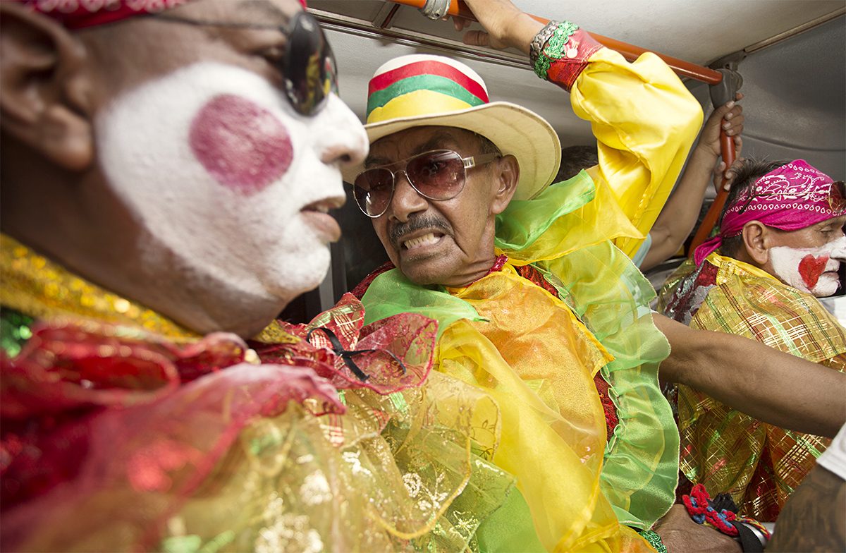 Three young performers laugh together in costume