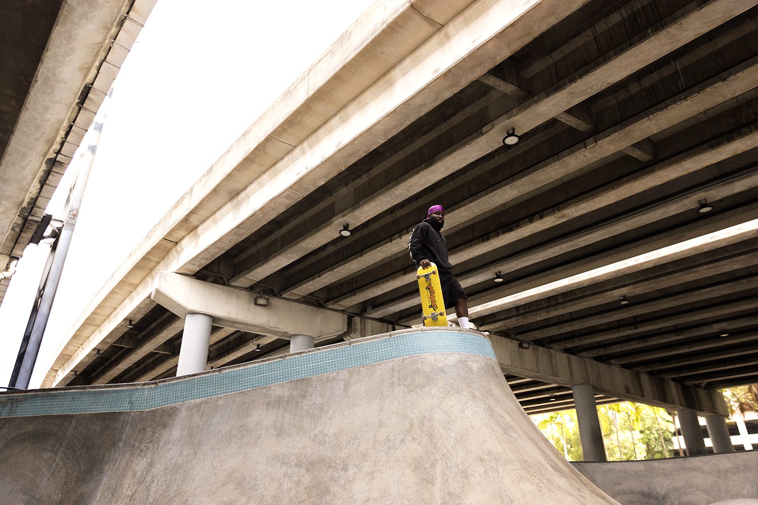 A skater rides a ramp in dappled light