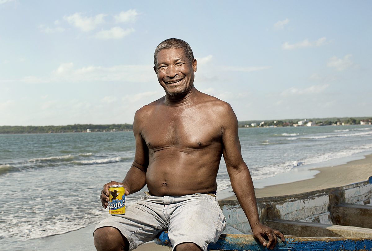 A fisherman relaxes on the beach with a beer
