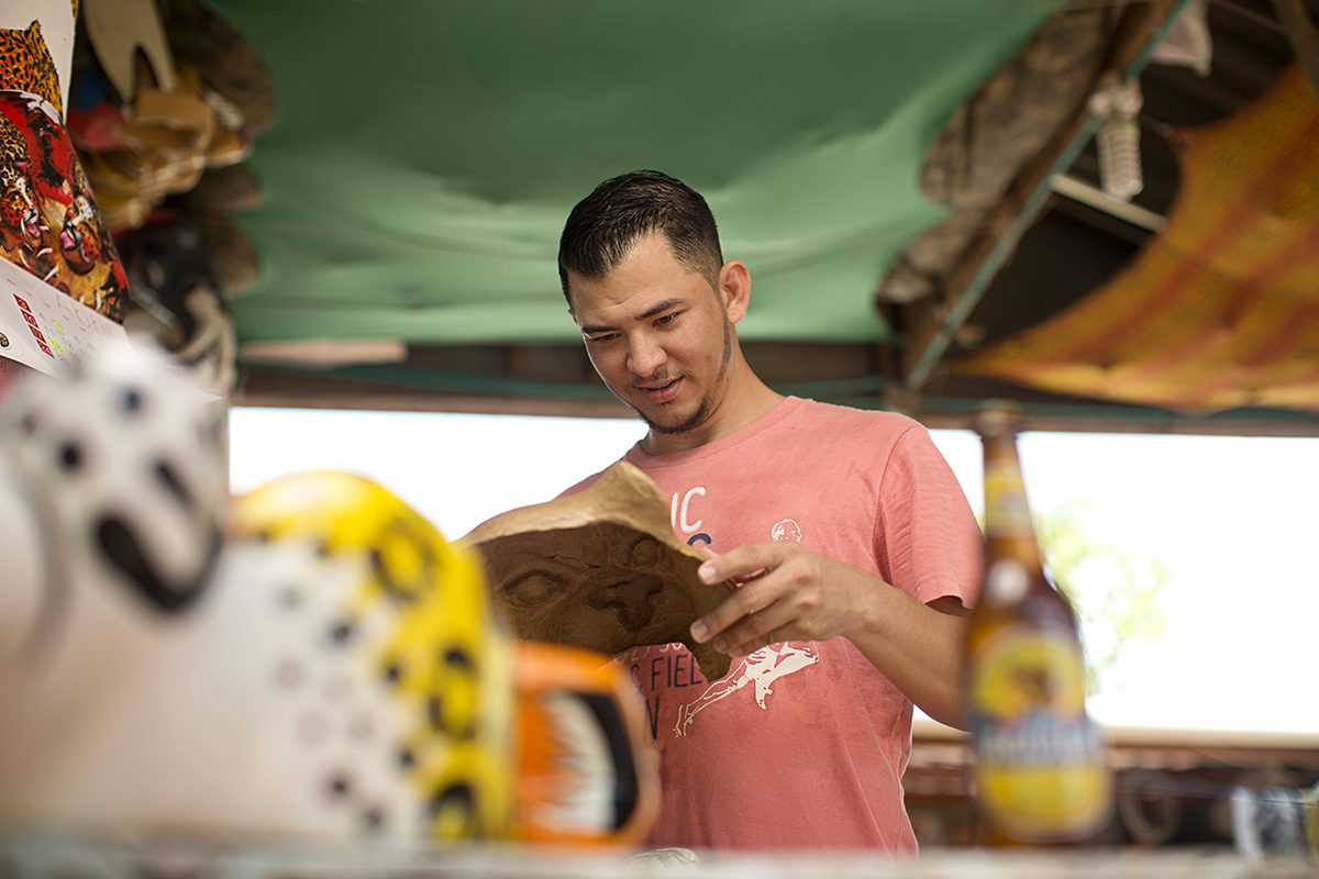 A young man reads with a beer in a colourful bar