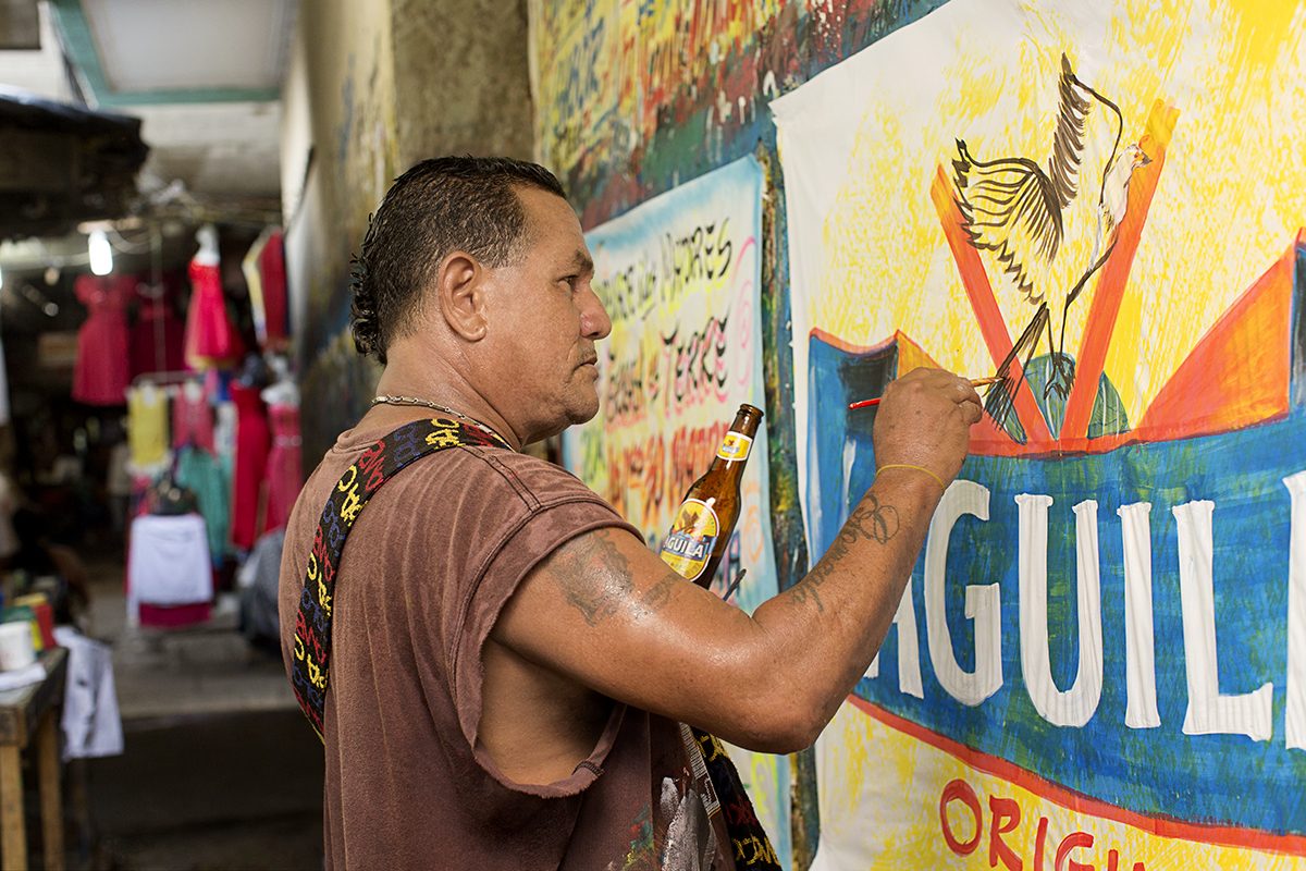 Detail of paintbrushes and a beer in an artisan workshop