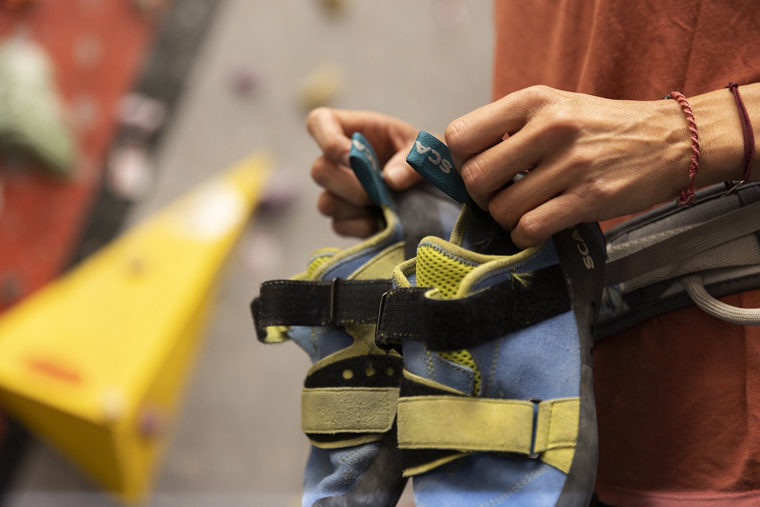 Close detail of hands checking the buckle of a climbing harness