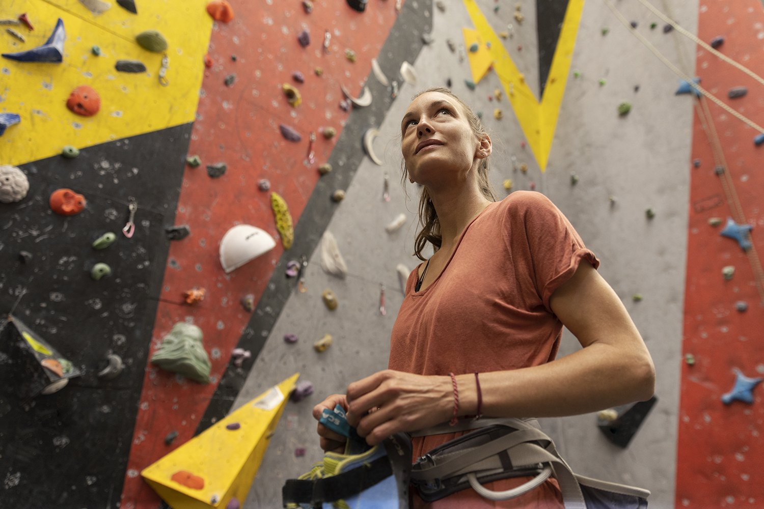 Standing back from the wall looking up at a route, rope over one shoulder
