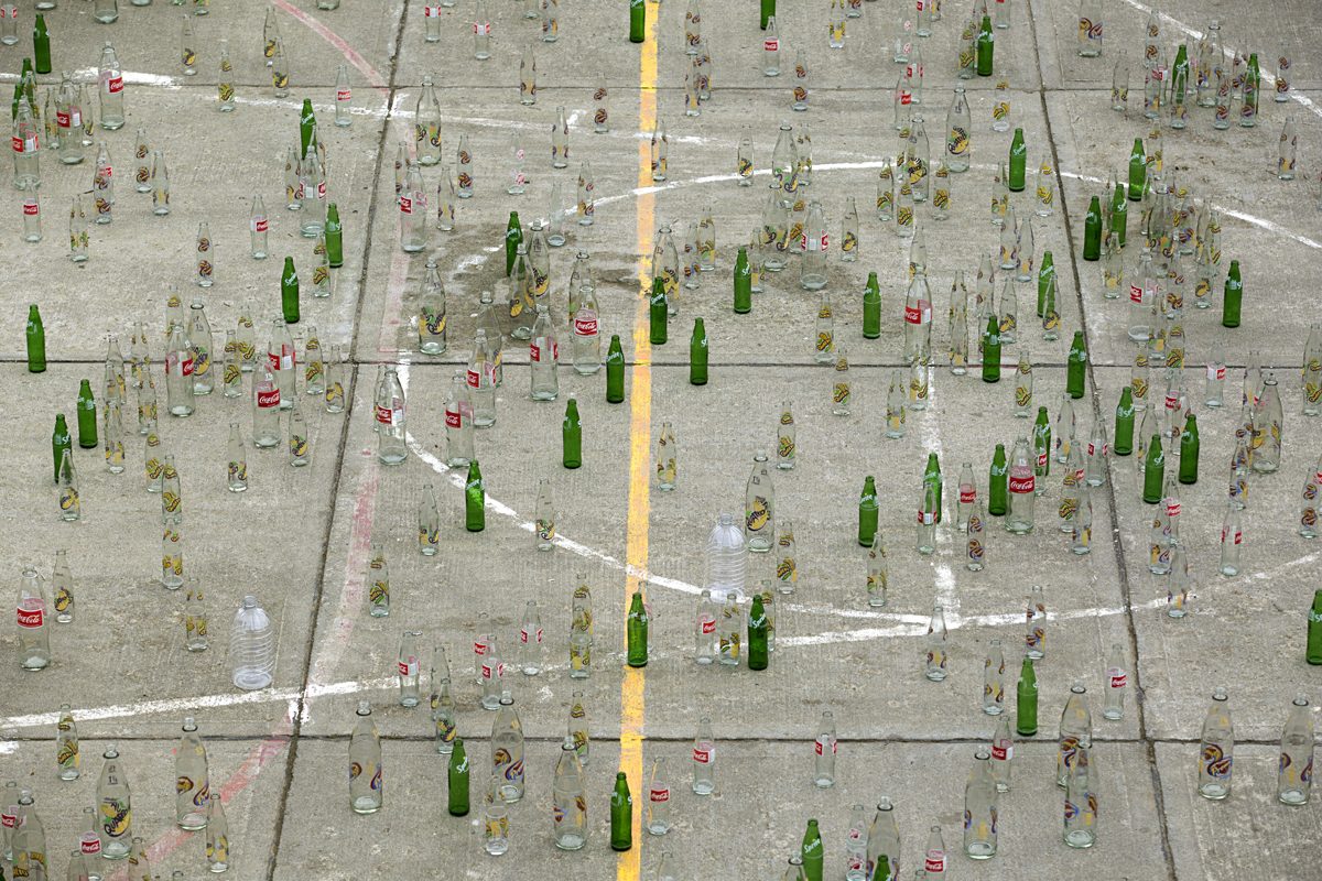 Grids of bottles set out in an open field to collect rainfall