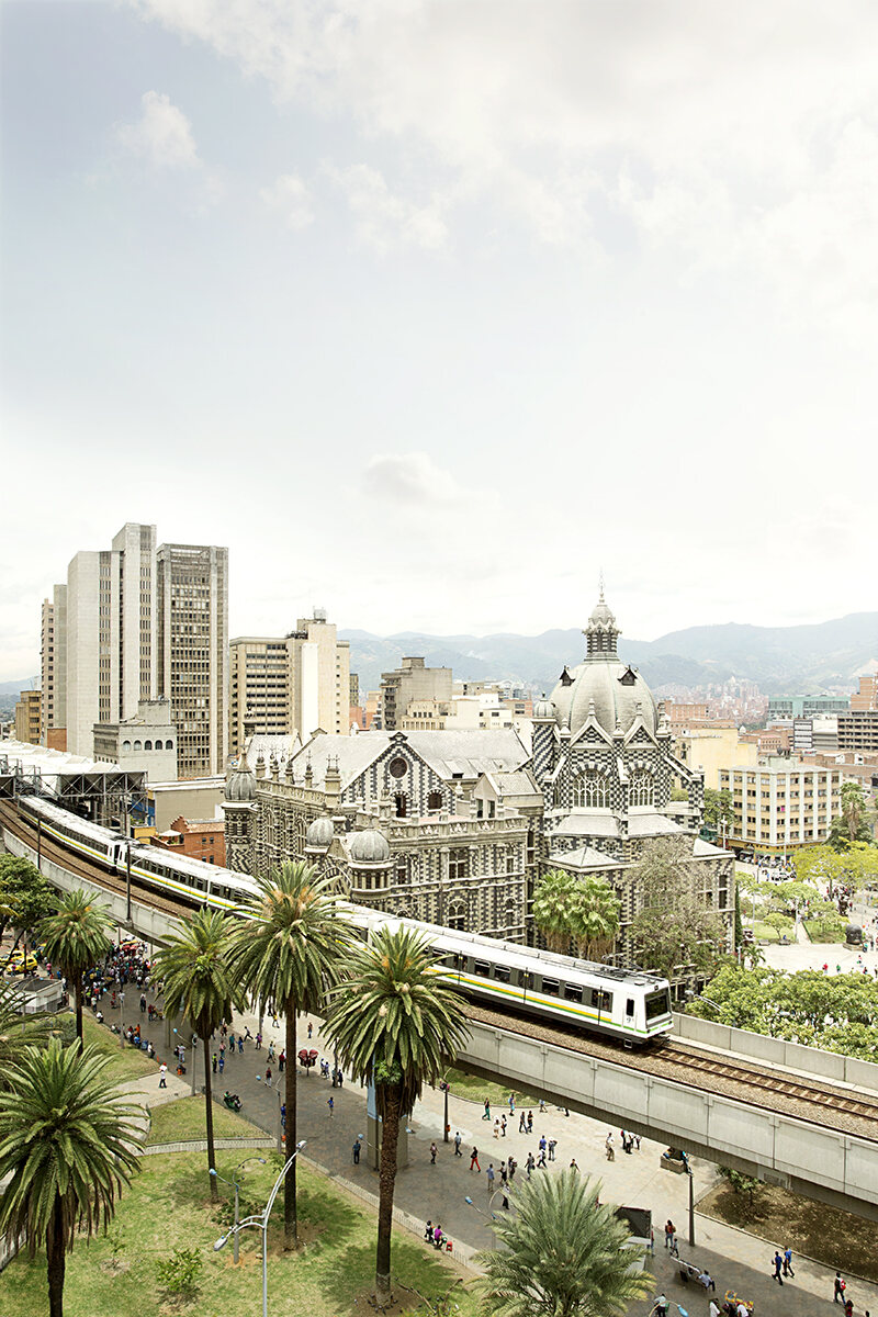 Plaza Botero and the Palace of Culture seen from above, train passing through