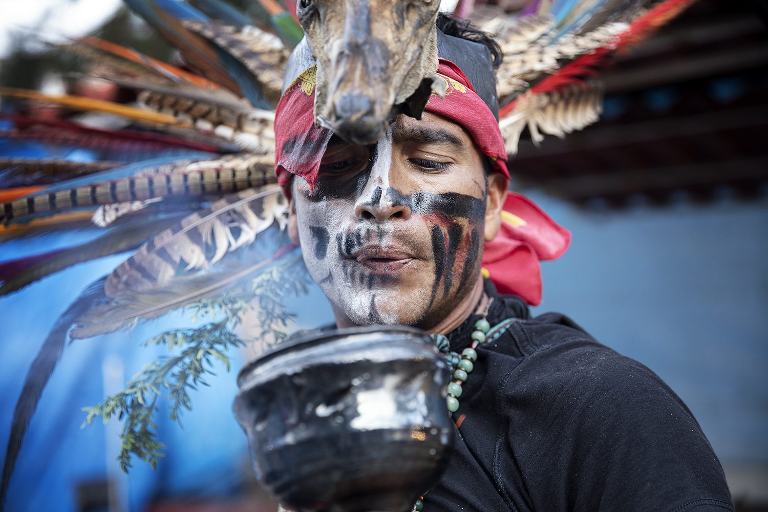 A man with painted Day of the Dead face and headdress