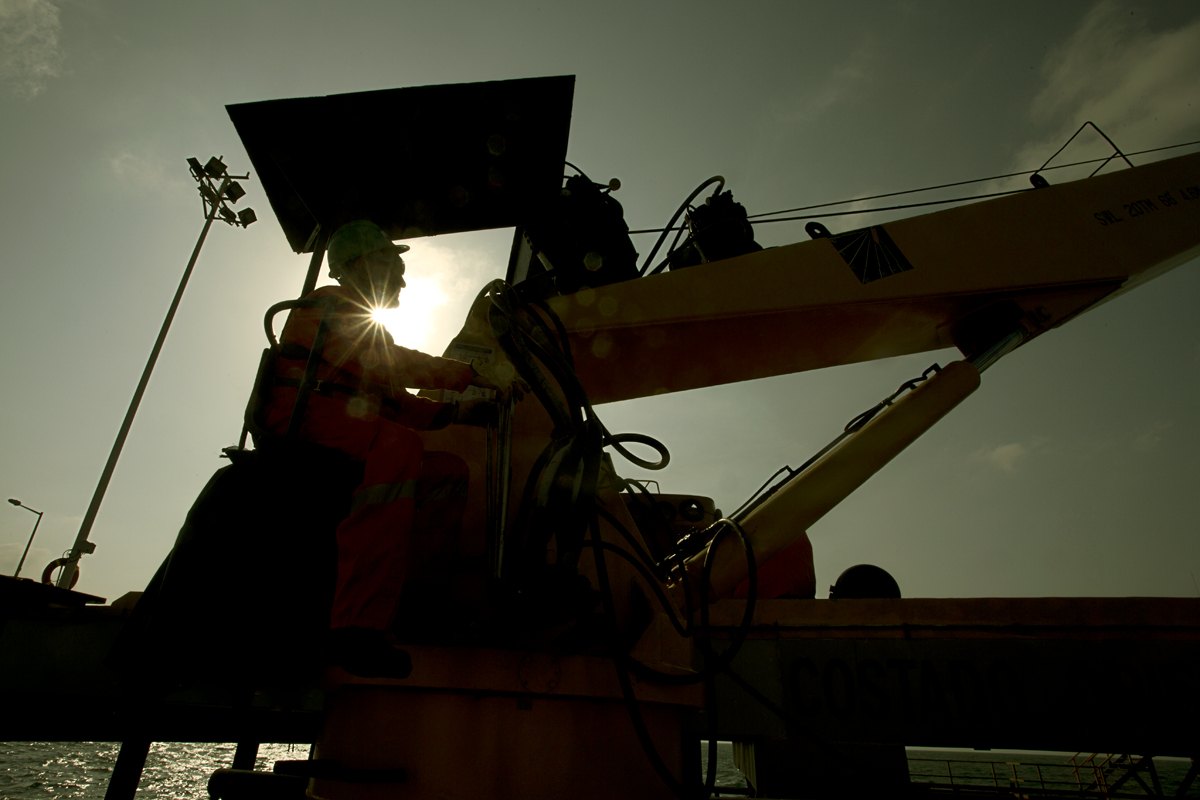 Heavy plant machinery picked out against a dark industrial interior