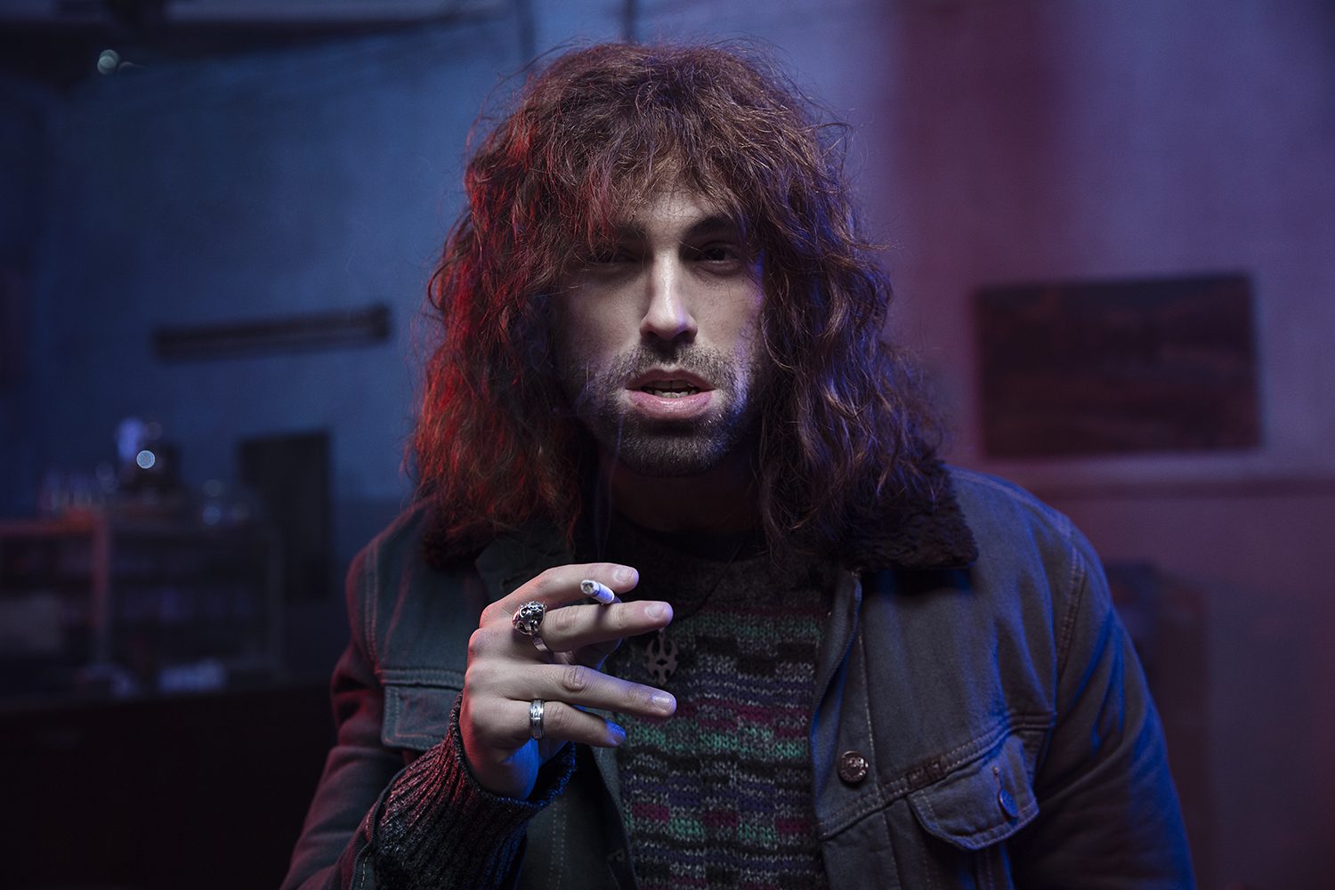 Cinematic red-lit portrait of a character smoking