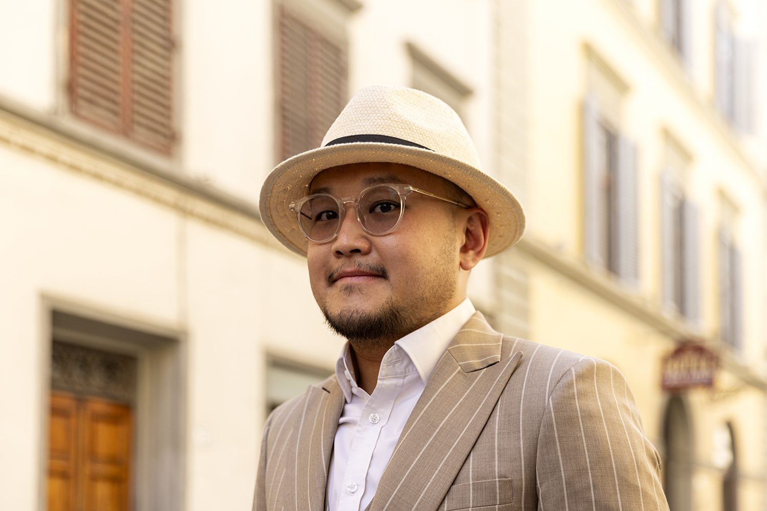 A well-dressed man in a hat on a Florence street