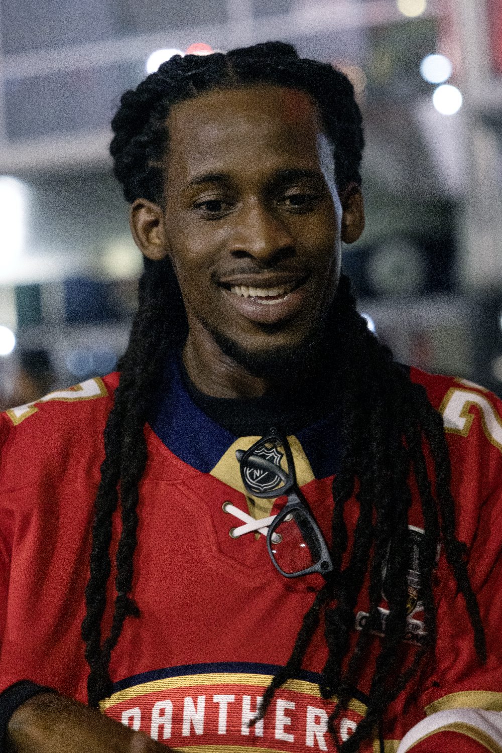 A smiling fan with long dreadlocks in a Panthers jersey