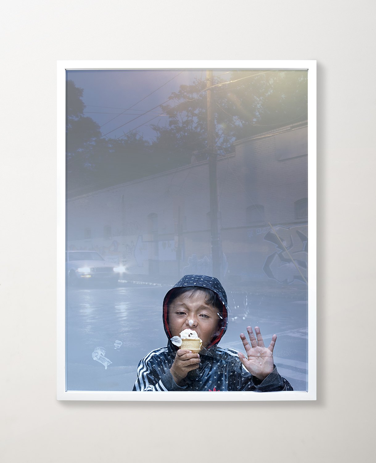 A framed frame of a figure in a cap holding a drink in heavy backlight