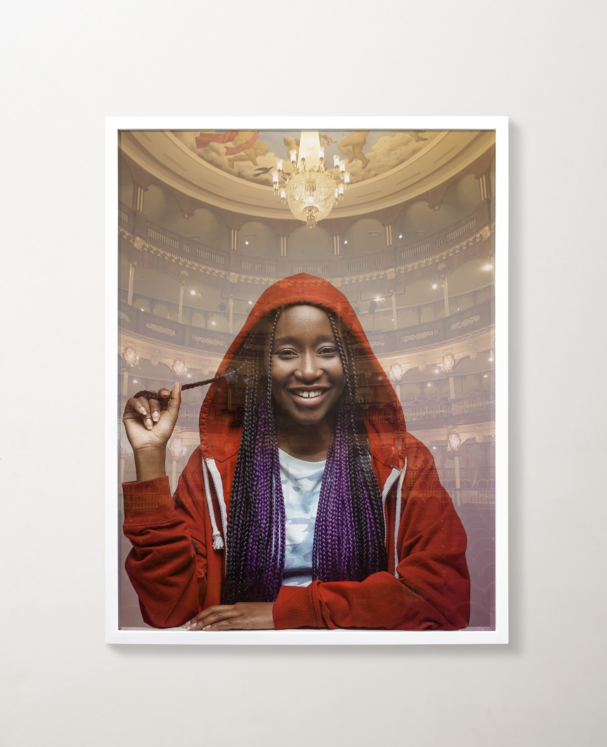A framed print of a woman in a red hood, gilded interior behind her