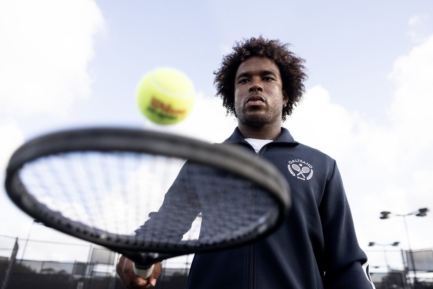 A player looks up, ball rising for the serve