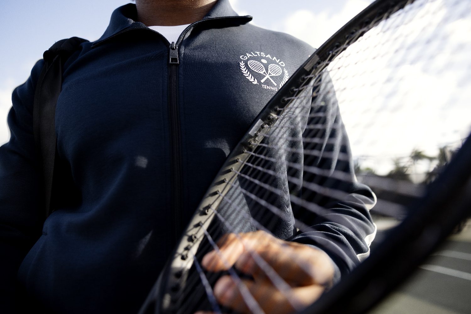 A player seen through the net, mid-court