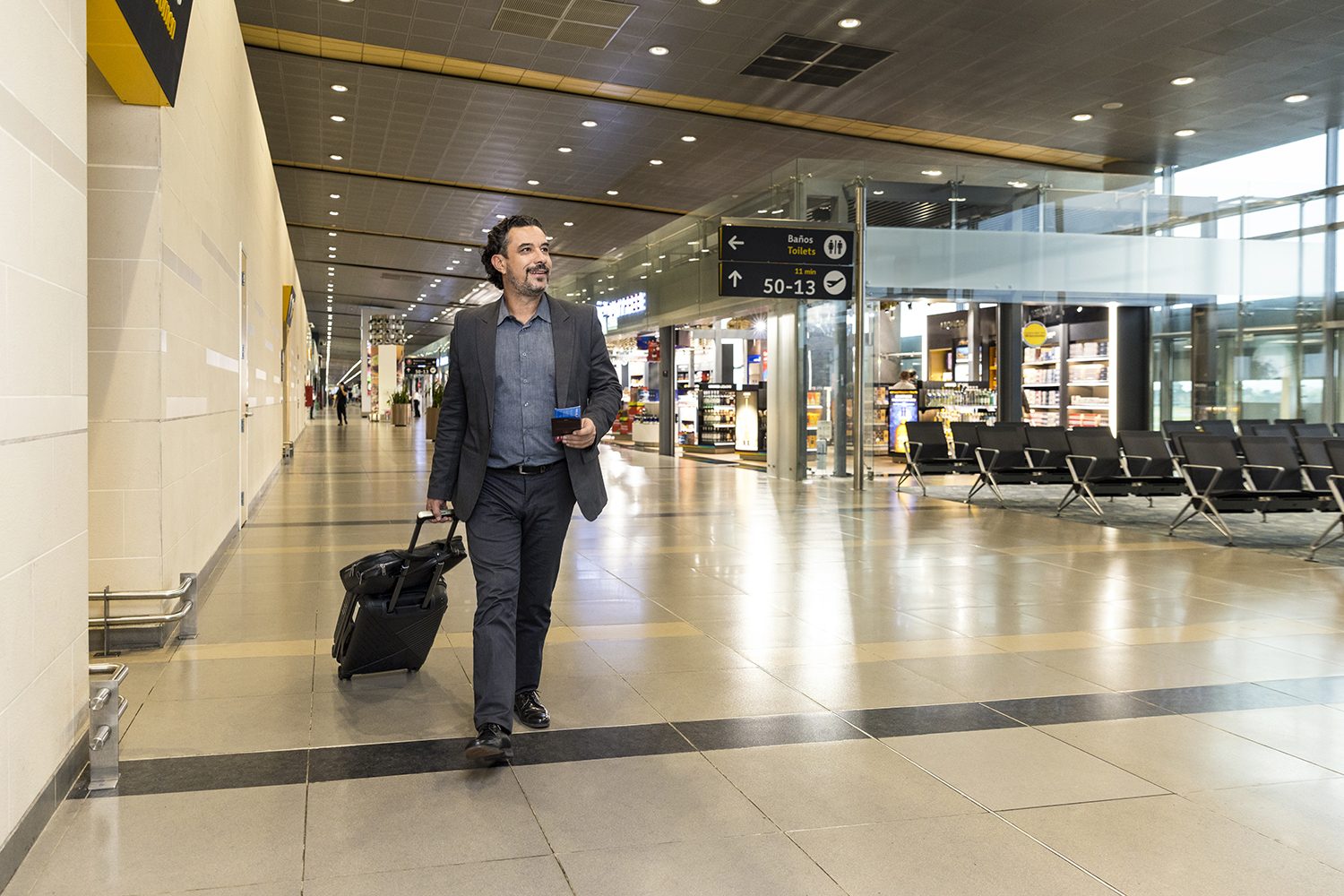 A businessman walks through the airport with luggage