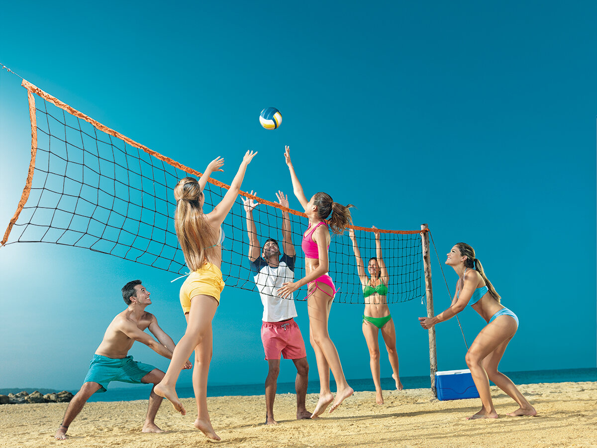 Beach volleyball match in full flight under a clear Caribbean sky