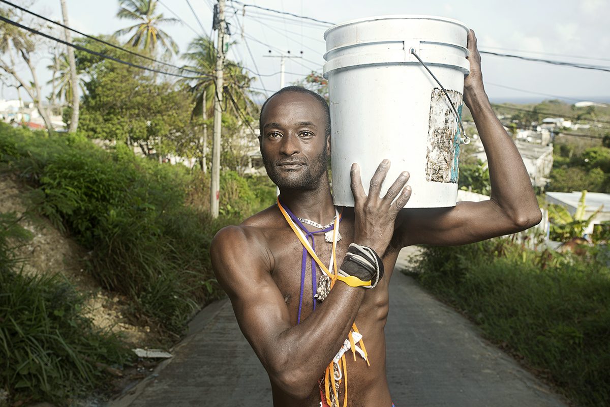 A man carries a water container along an island path