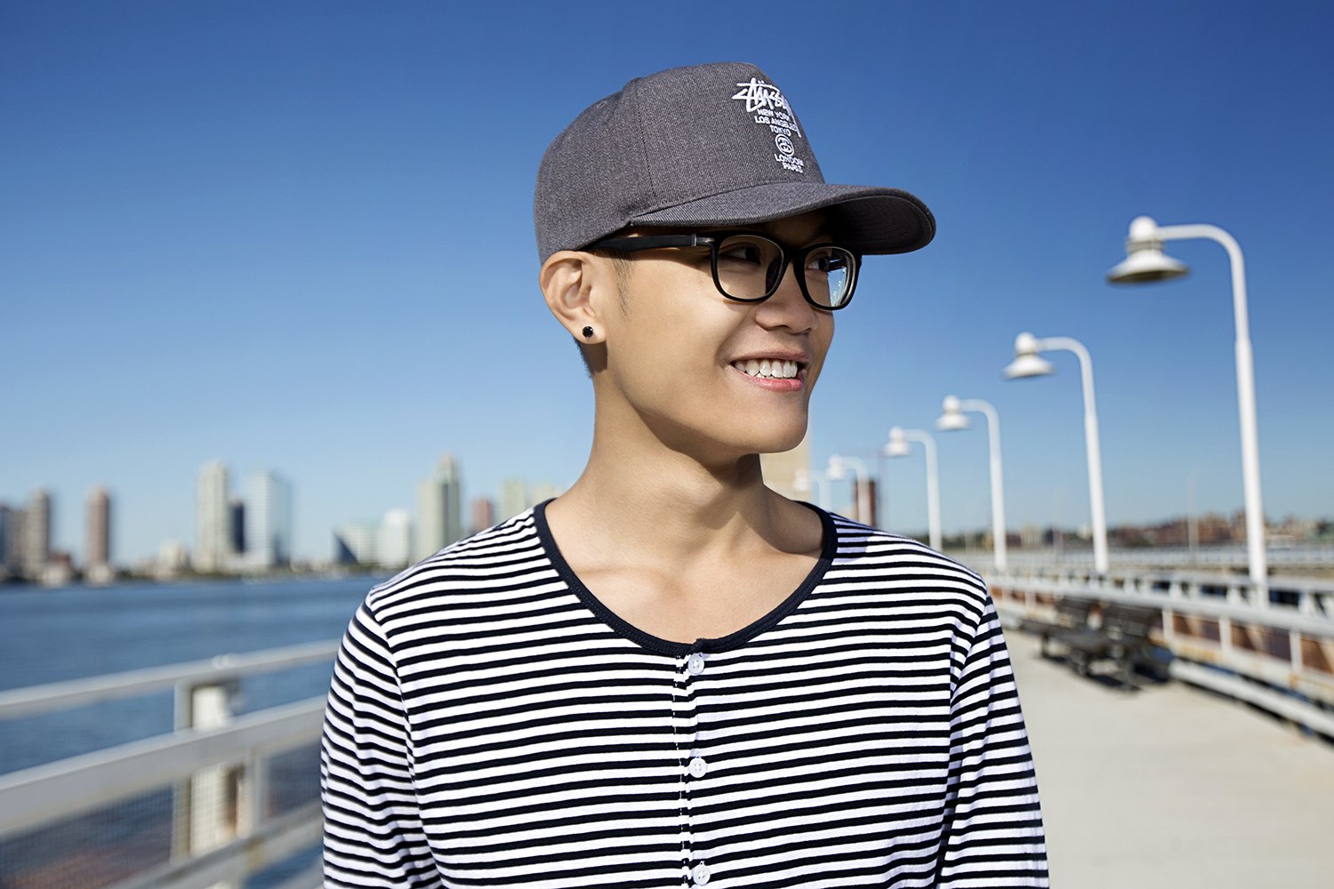 Portrait in a cap and striped top, the river and towers thrown out of focus behind