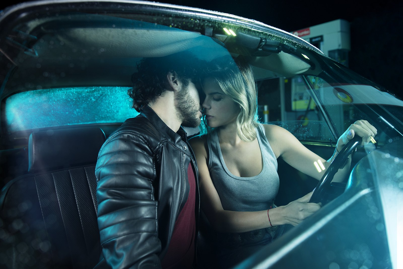 Two women in the front seats laughing on a night drive through the city
