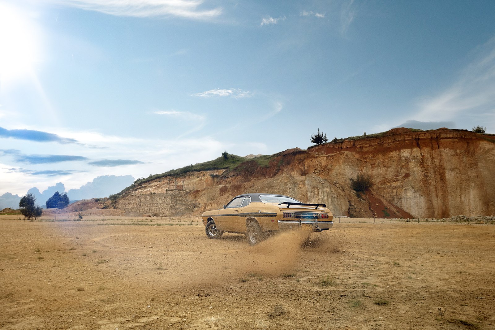 A single car small on a dirt road cutting through arid country under a wide sky