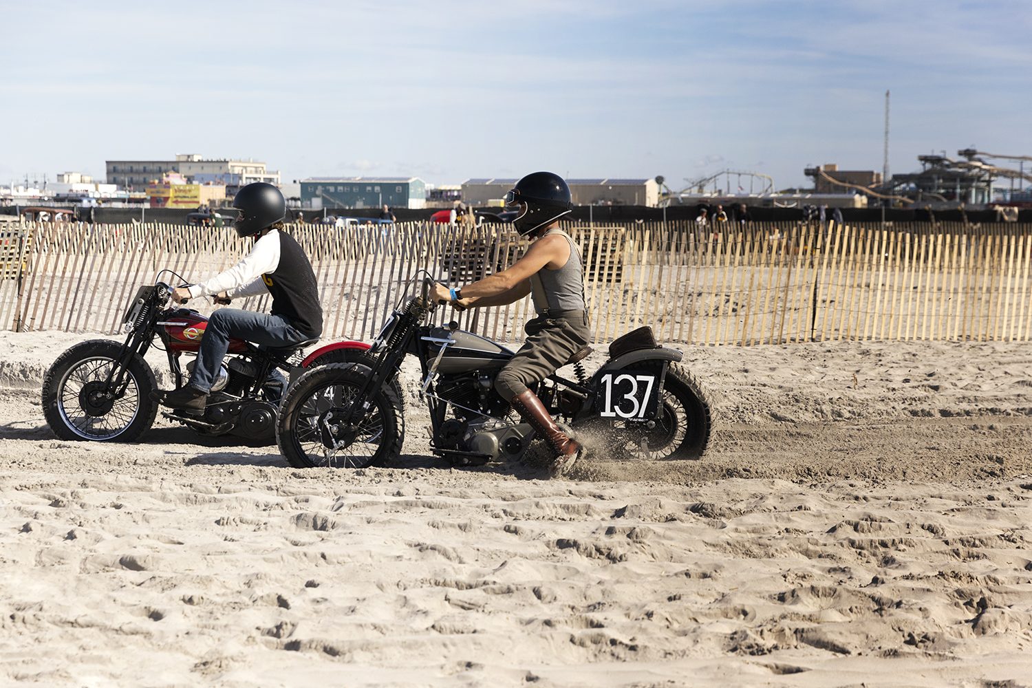 Two riders line up their motorcycles on the sand