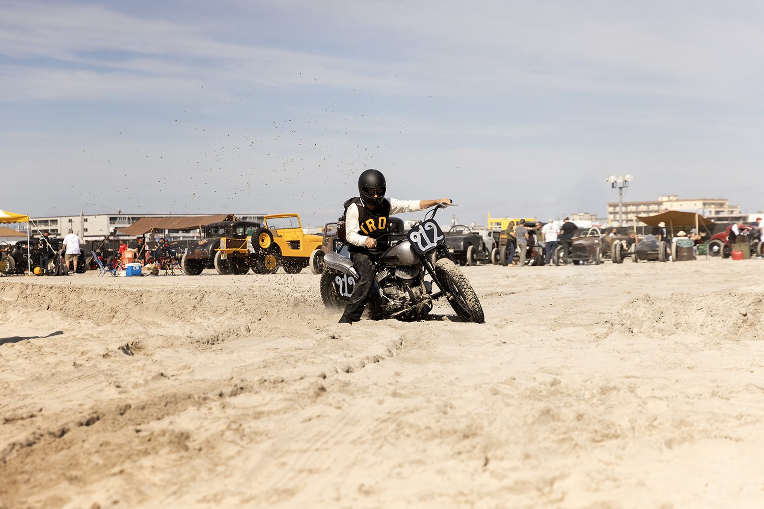 A lone rider on the beach with the event behind