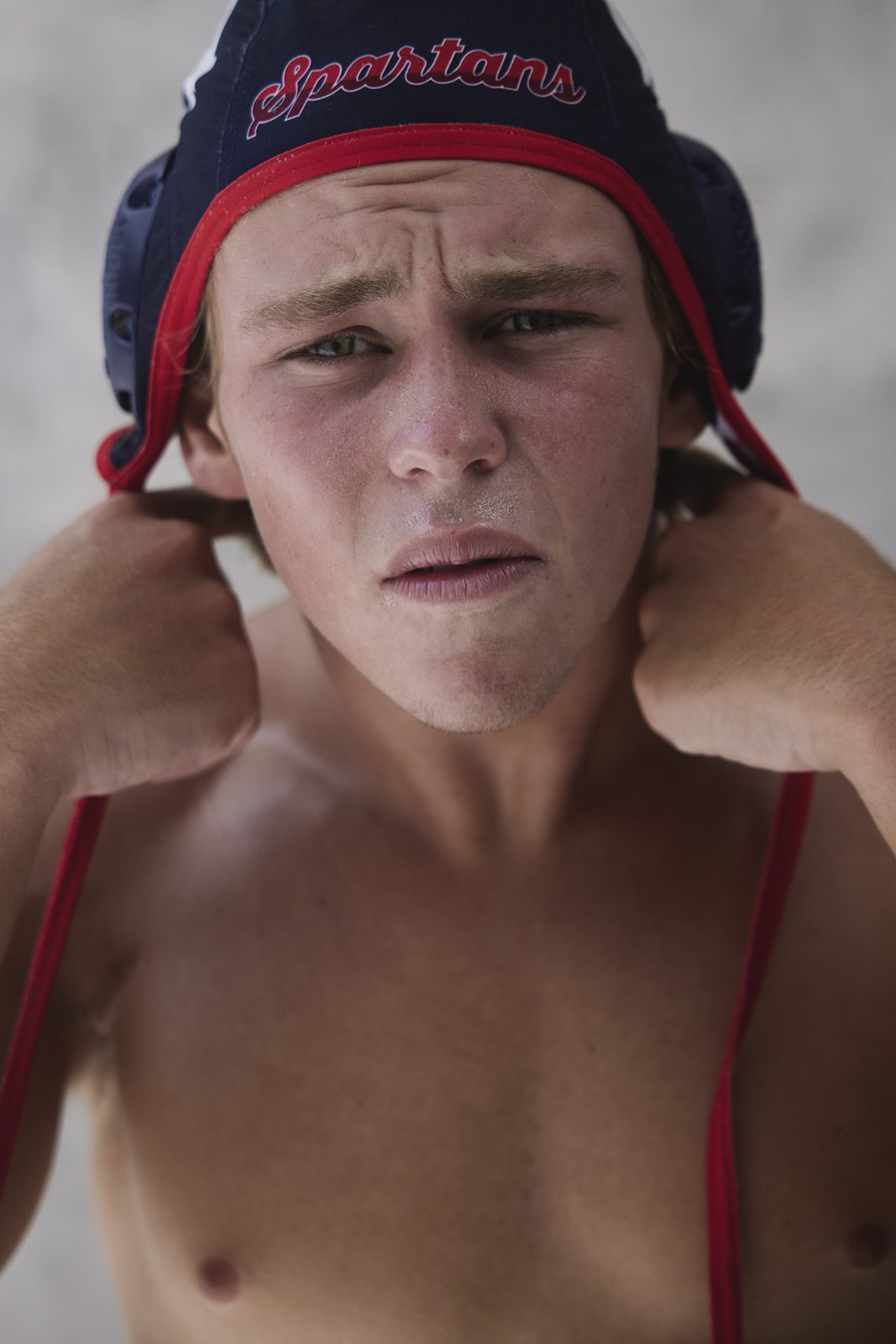 A young player in a red cap, wet from the pool