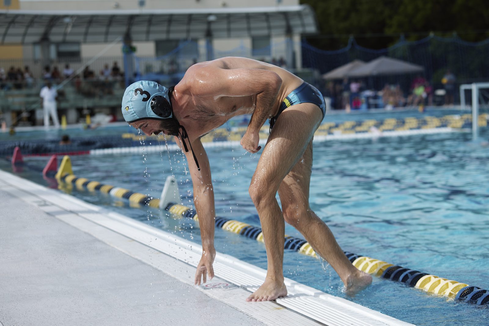 A player stretches at the pool edge before a set