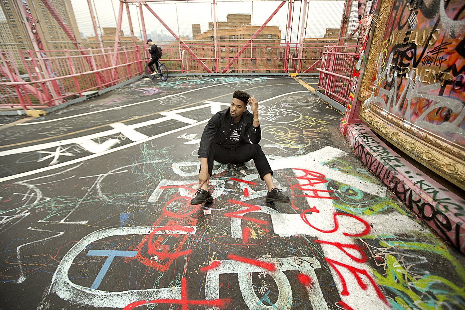 Sitting on the lip of a graffiti-covered concrete bowl, tags running in every direction