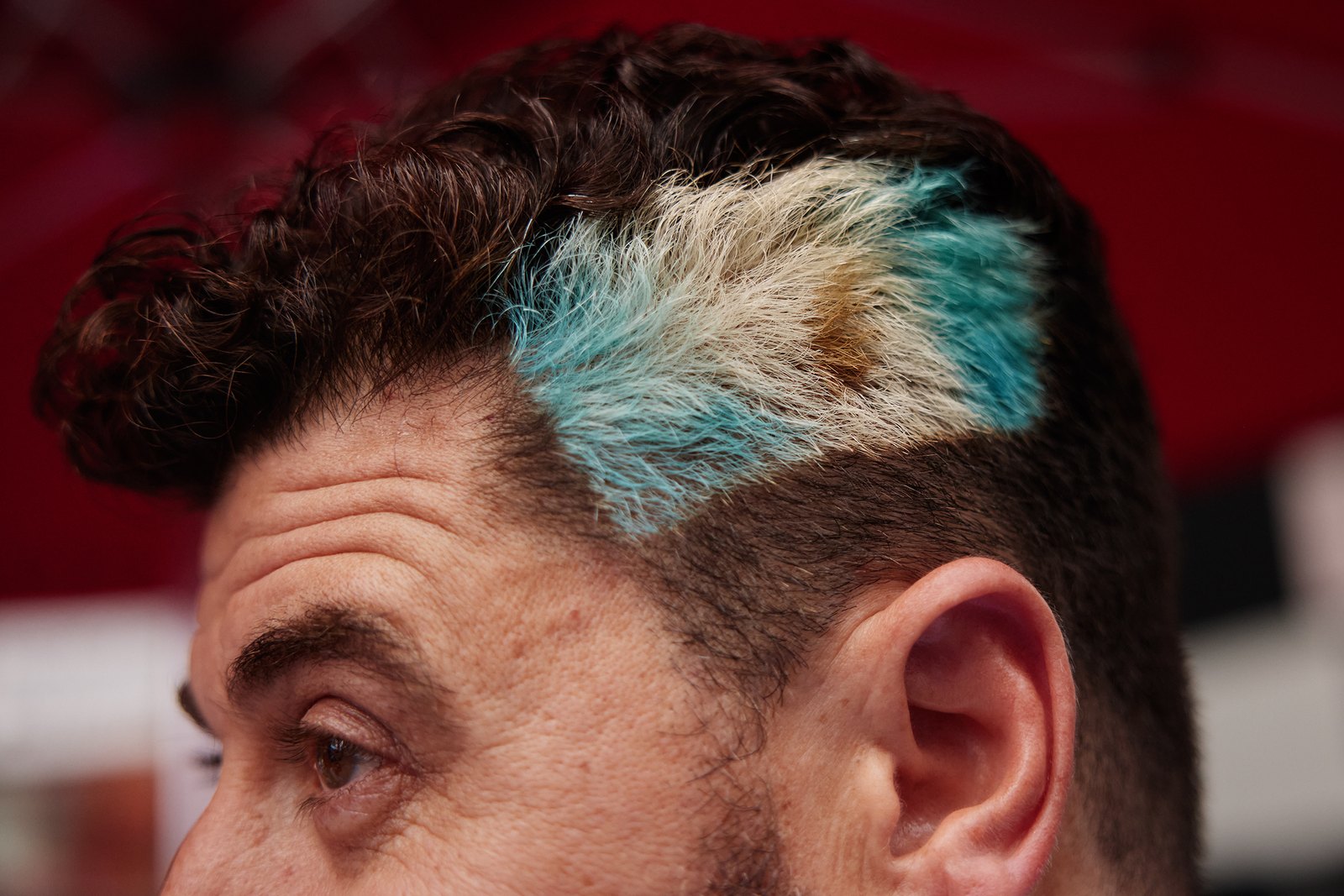 Close-up of a fan whose hair has been dyed in sky blue and white Argentina stripes