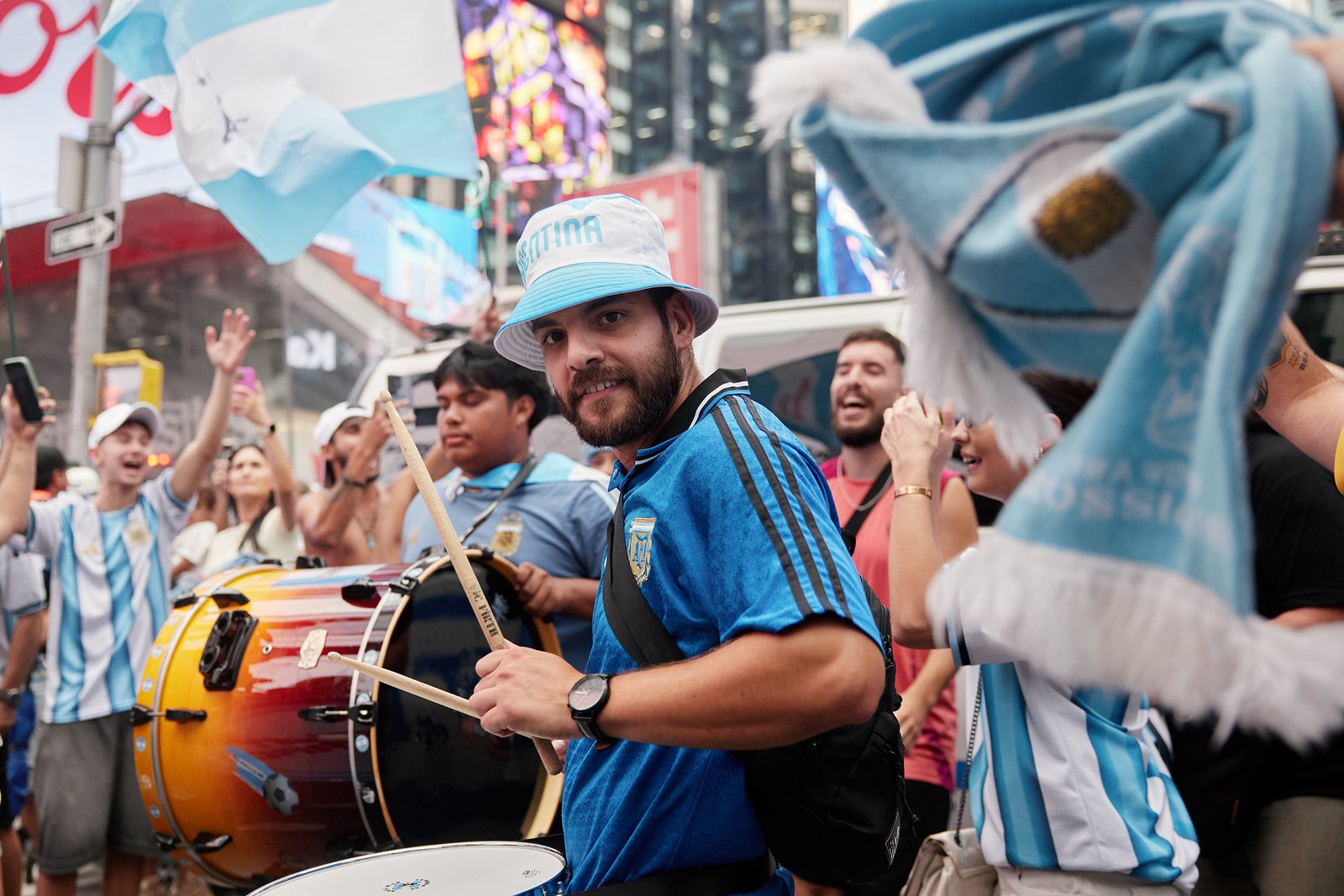 Argentina drummers in bucket hats and scarves lead the crowd through Times Square