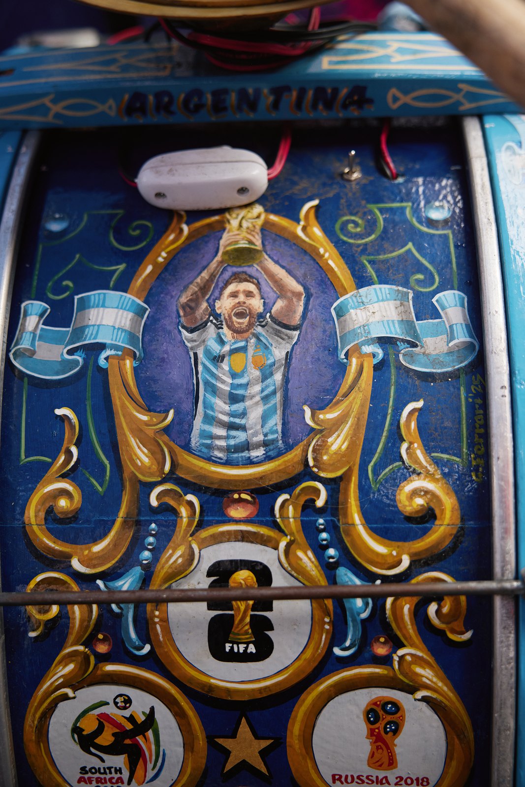 A hand-painted bass drum showing Messi lifting the trophy, ringed with past World Cup badges